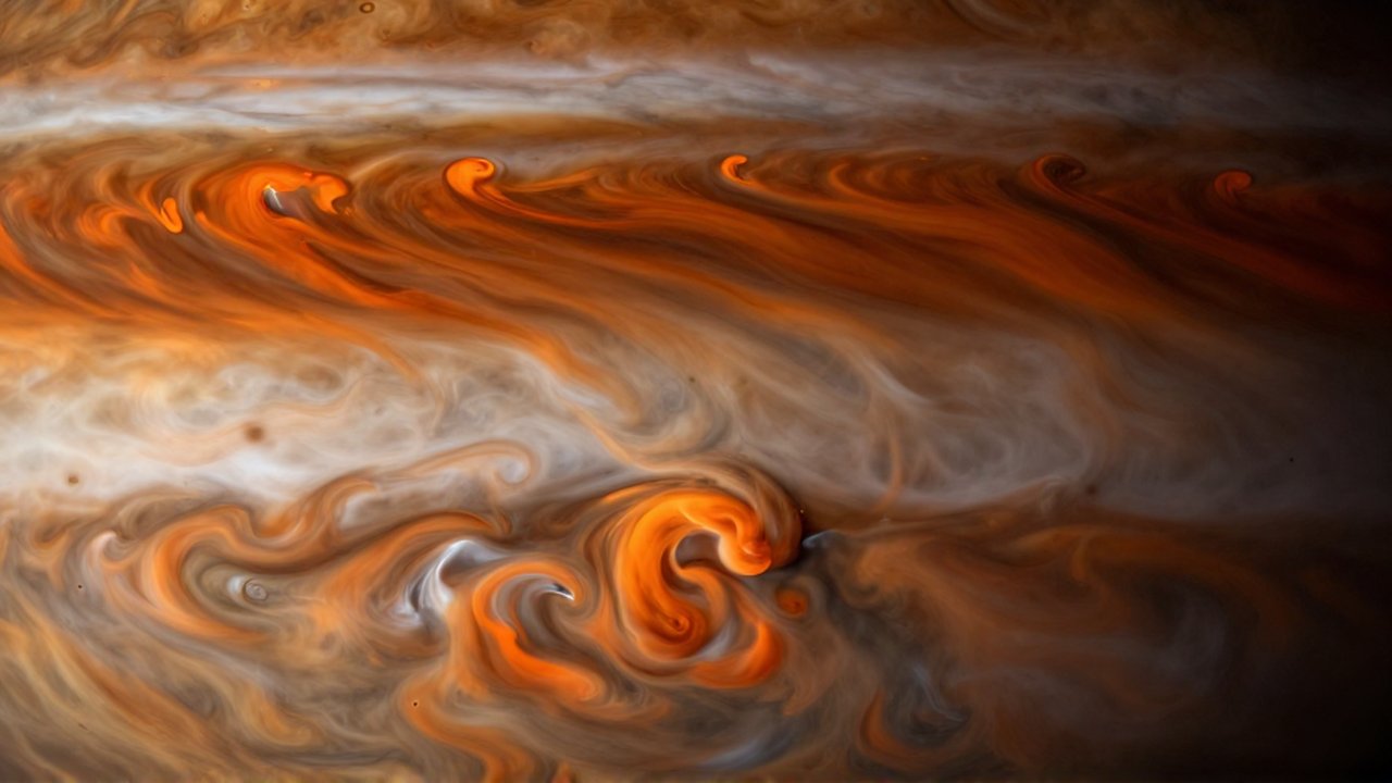 Turbulentas nubes de hidrógeno color ocre se comprimen en un fluido denso bajo la presión atmosférica de Júpiter.